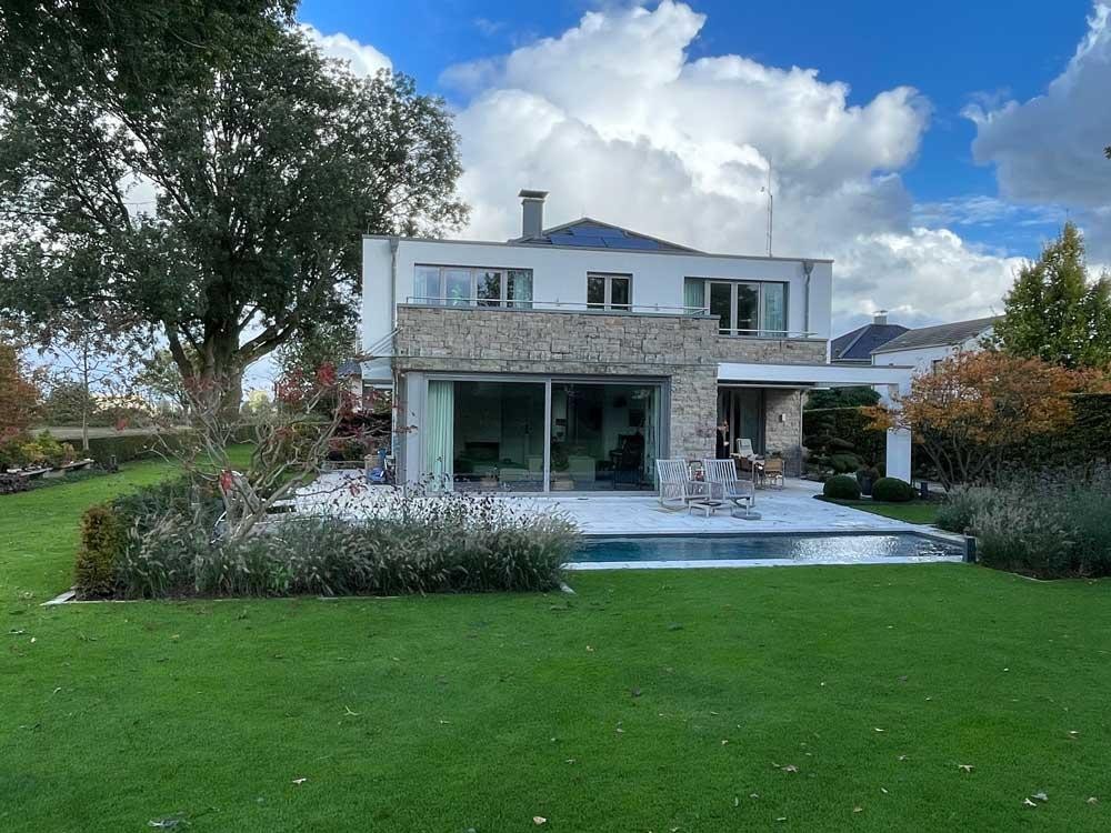 Biopool devant une villa moderne avec terrasse et jardin soigné