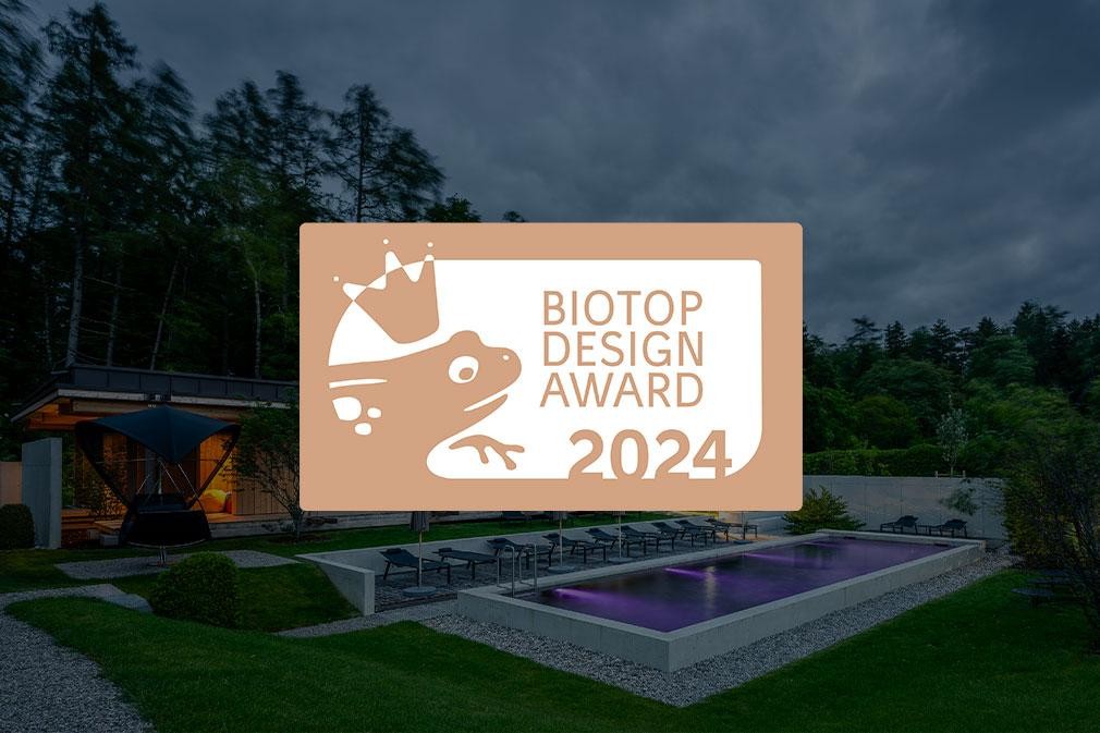 Grand biopool dans le jardin de l’hôtel avec transats et architecture moderne