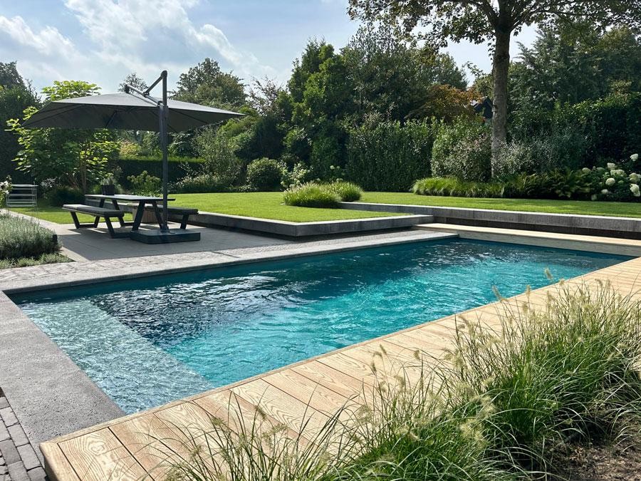 Piscine design avec parasol et terrasse dans un jardin moderne