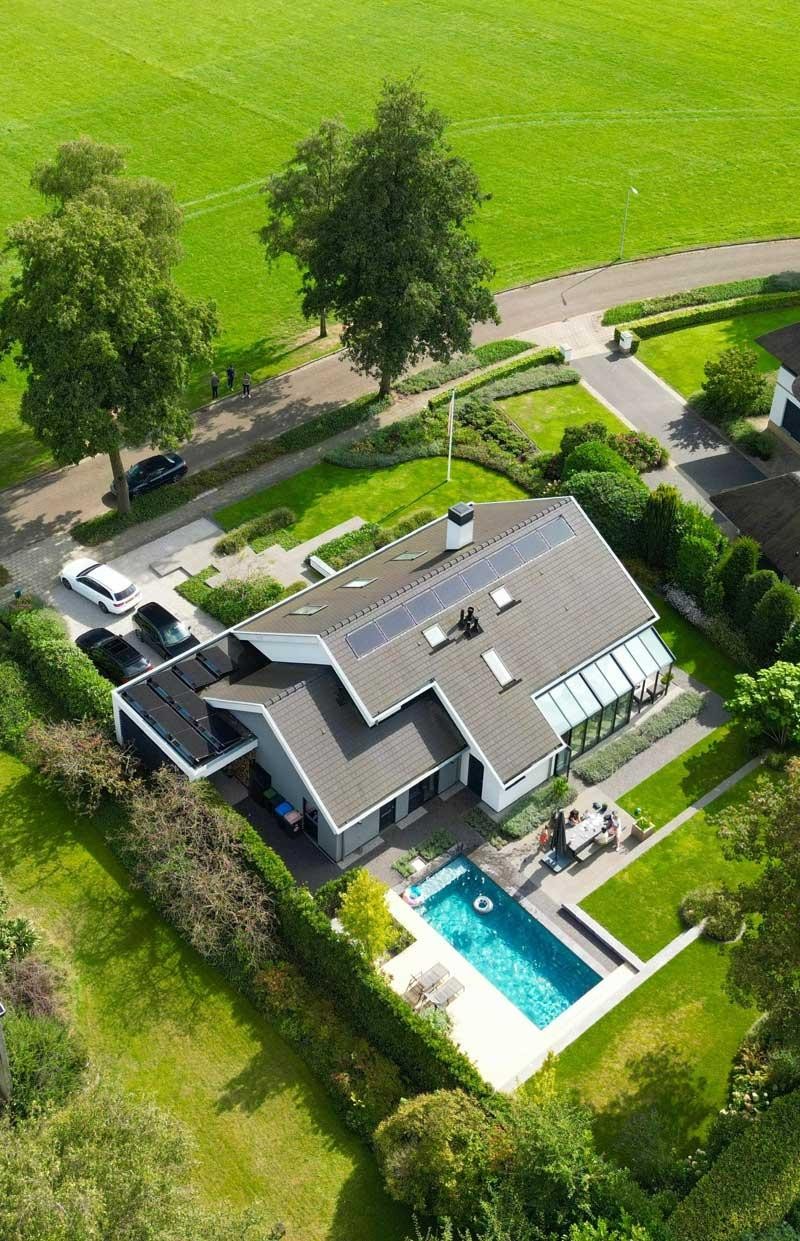 Vue aérienne d’une piscine design et d’une maison individuelle au jardin
