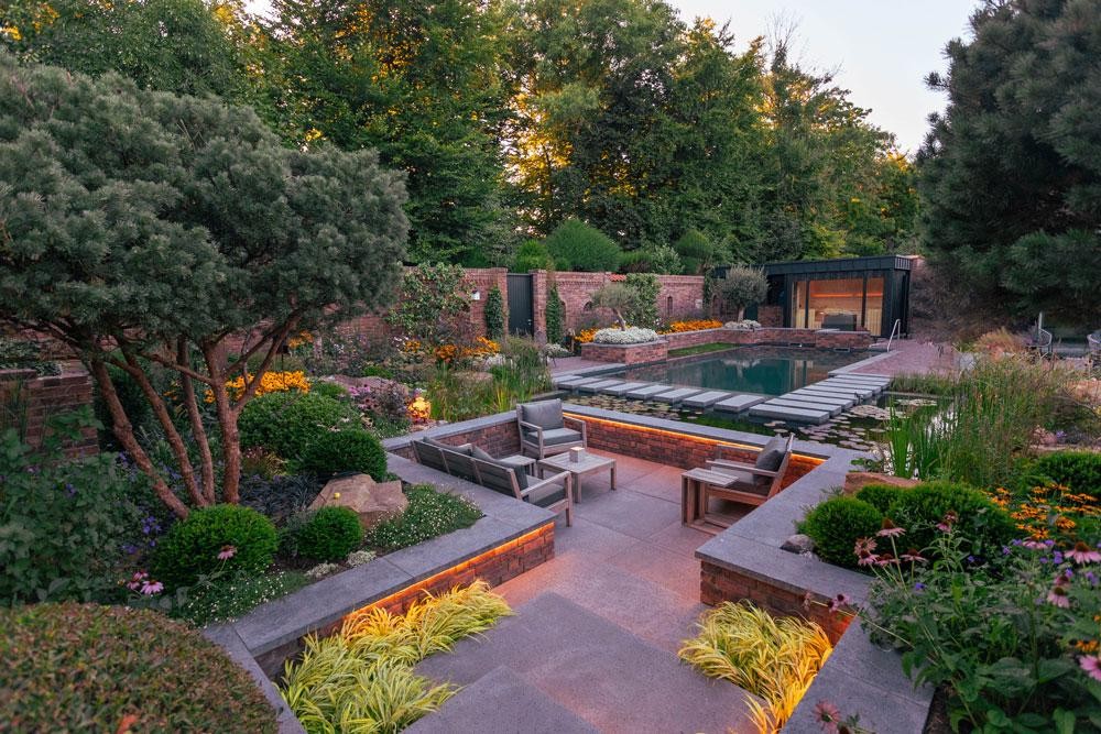 Piscine naturelle avec salon et eclairage de jardin chaleureux