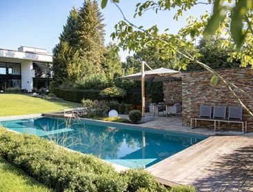 Une maison avec une piscine naturelle et une terrasse de style moderne