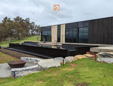 Une vue sur la piscine naturelle et la terrasse d'une maison moderne