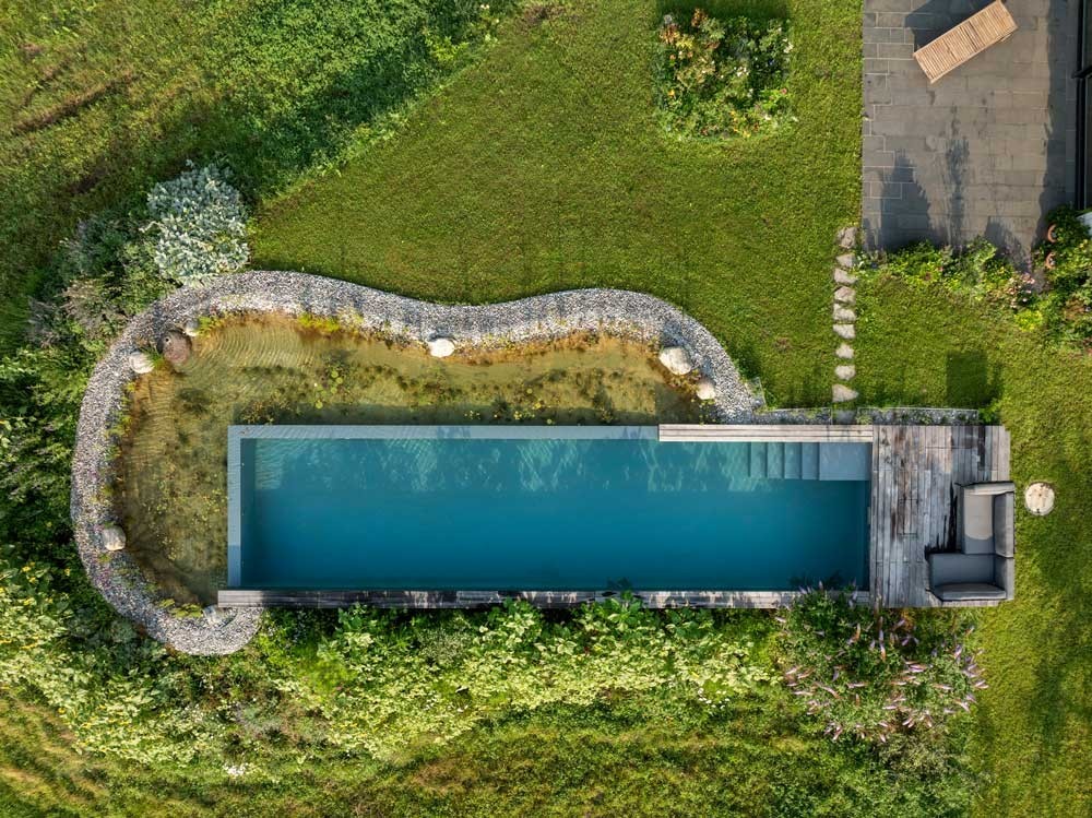 Piscine naturelle moderne avec effet infinity et zone de régénération vue du ciel