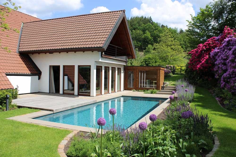Piscine naturelle avec rhododendrons et jardin fleuri