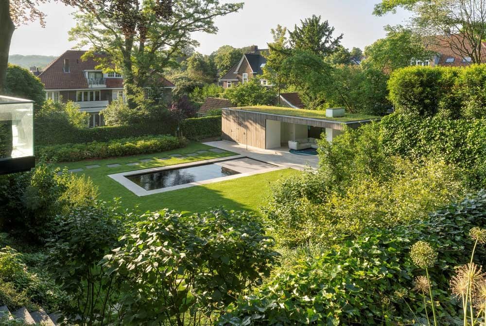 Piscine naturelle dans un grand jardin avec poolhouse et toit végétalisé