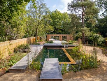 Entouree de grands arbres cette Swimming Pond devient le point central du jardin