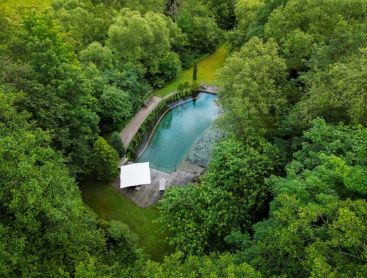 Vue aérienne d un étang de baignade naturel entouré d arbres et de nature